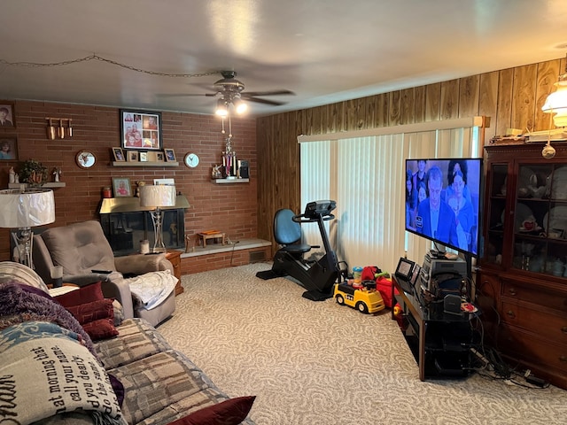 1022 S E E, Bucyrus, OH 44820 - living room featuring carpet floors, a ceiling fan, wood walls, and brick wall