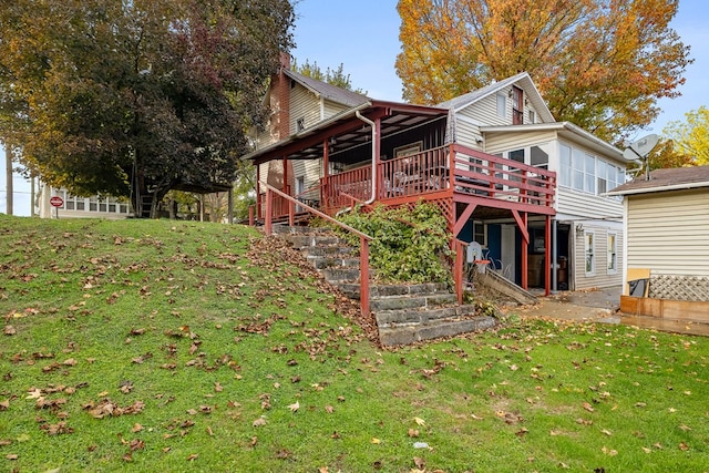 rear view of house featuring a deck and a yard