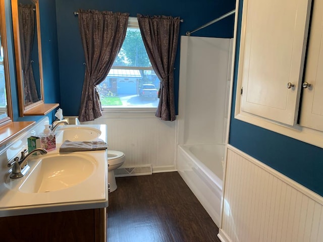 1149 Robinhood Dr, Bucyrus, OH 44820 - full bathroom featuring a wainscoted wall, double vanity, shower / bathtub combination, and wood finished floors