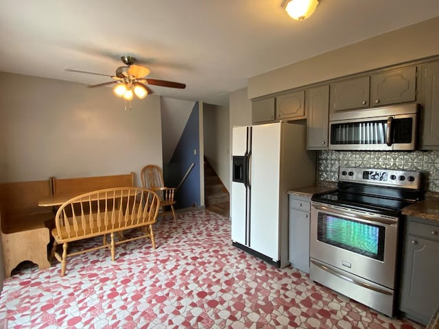 1149 Robinhood Dr, Bucyrus, OH 44820 - kitchen featuring stainless steel appliances, gray cabinetry, light floors, dark countertops, and ceiling fan