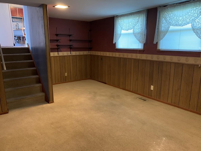 1149 Robinhood Dr, Bucyrus, OH 44820 - basement featuring light carpet, wood walls, a wainscoted wall, and stairs