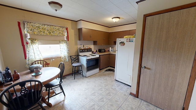 kitchen with crown molding and white appliances