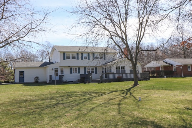 colonial-style house featuring a wooden deck and a front lawn