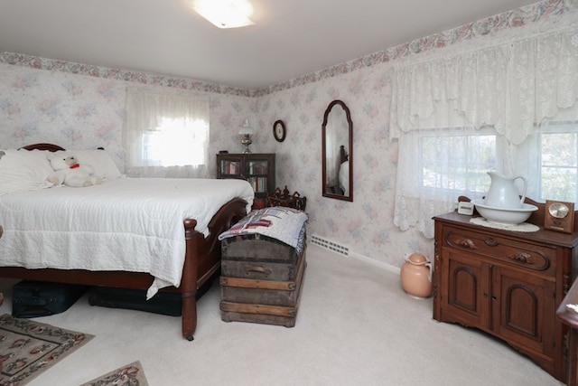 bedroom with visible vents, light colored carpet, wallpapered walls, and multiple windows