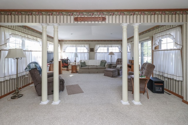 living room with carpet, baseboards, wallpapered walls, decorative columns, and crown molding
