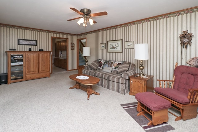 living area featuring wallpapered walls, light carpet, stairs, and ceiling fan