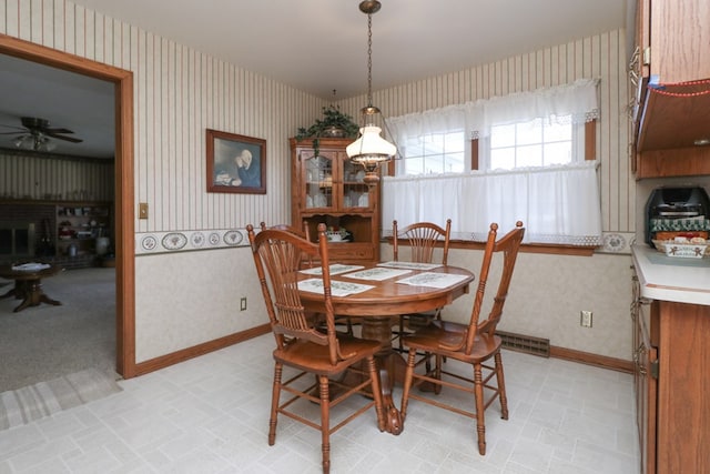 dining area featuring wallpapered walls, a ceiling fan, and baseboards