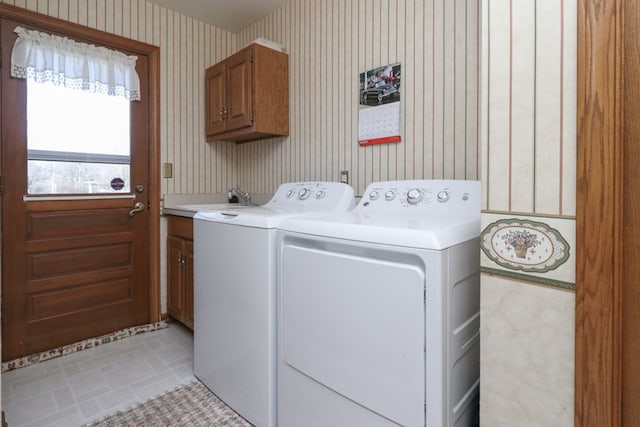 laundry area featuring a sink, cabinet space, independent washer and dryer, and wallpapered walls