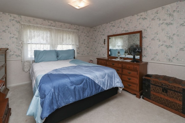 bedroom featuring wallpapered walls, carpet, and a wainscoted wall