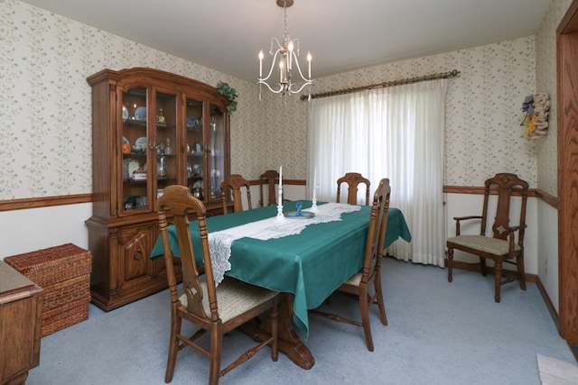 dining space with light colored carpet, wallpapered walls, and an inviting chandelier