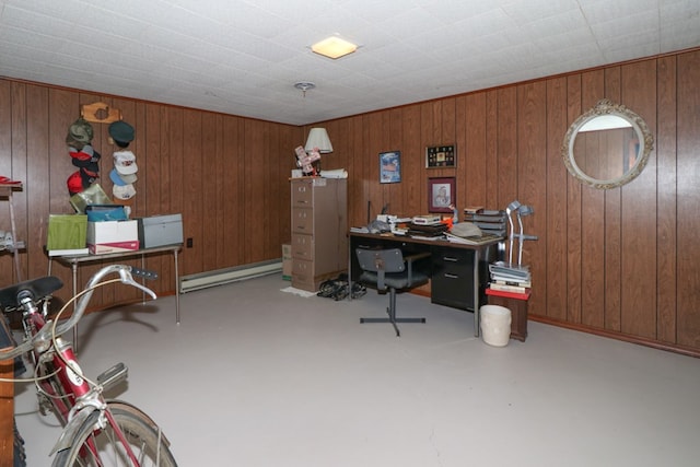 office area featuring a baseboard radiator, concrete floors, and wood walls