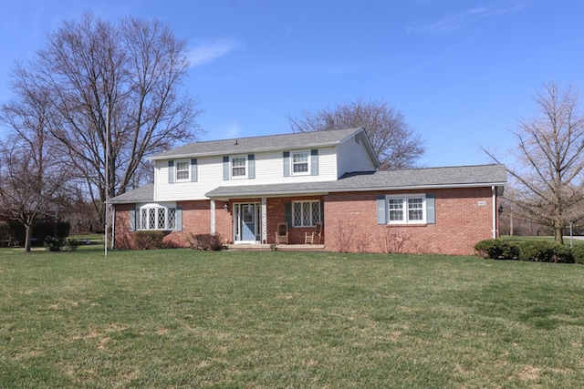 traditional home featuring a front yard, brick siding, and a shingled roof