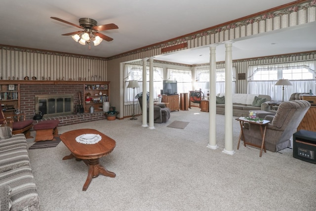 carpeted living area with a fireplace, a ceiling fan, and ornate columns