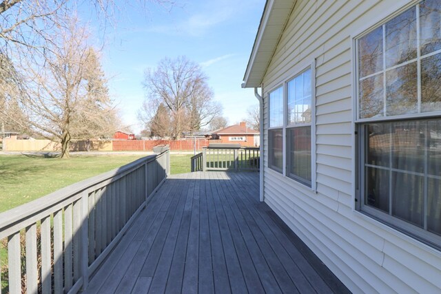 wooden deck featuring a lawn and fence