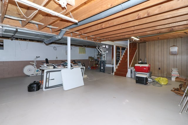 unfinished below grade area featuring stairway and heating unit
