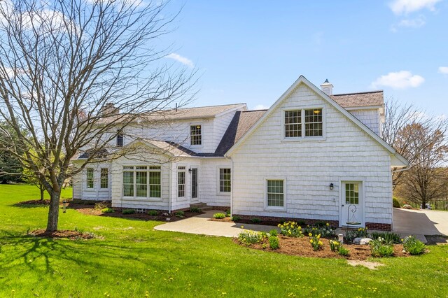 rear view of property with a lawn and a chimney