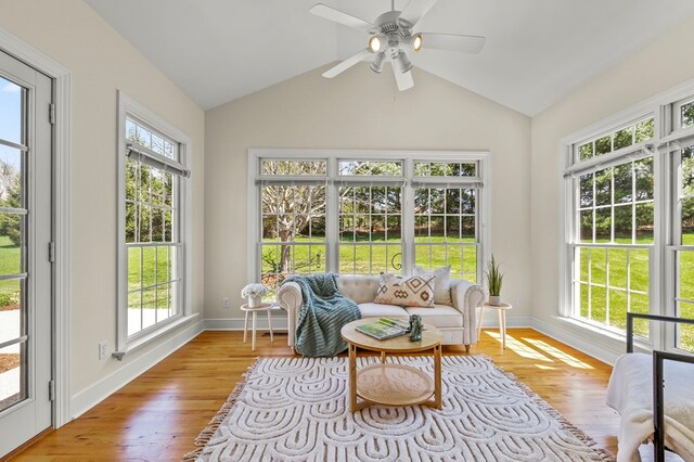 sunroom with lofted ceiling, wood finished floors, and baseboards