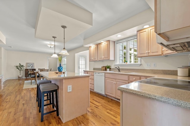 kitchen with a center island, dishwasher, light brown cabinetry, and light wood finished floors