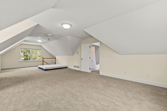 additional living space featuring lofted ceiling, baseboards, visible vents, and carpet