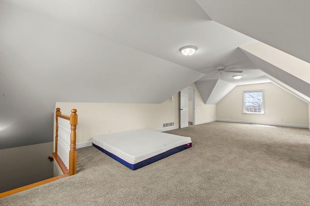 carpeted bedroom with lofted ceiling, visible vents, and baseboards