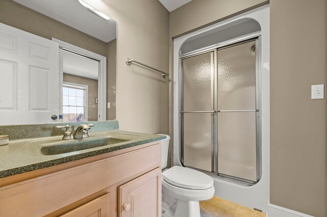 full bath with toilet, vanity, and a stall shower
