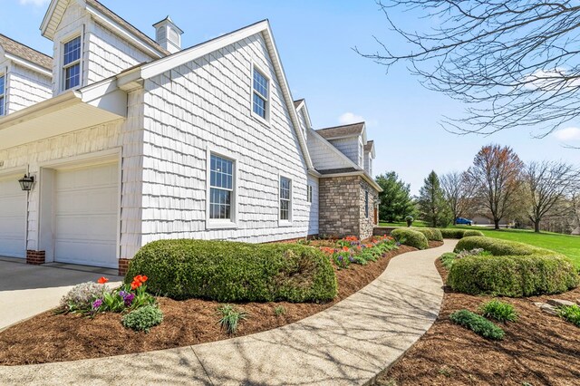 view of property exterior with driveway and a chimney