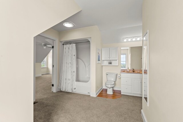 bathroom with toilet, vanity, a shower with shower curtain, and baseboards
