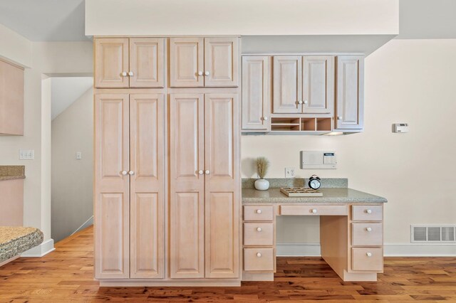 kitchen featuring light countertops, visible vents, light wood finished floors, and baseboards