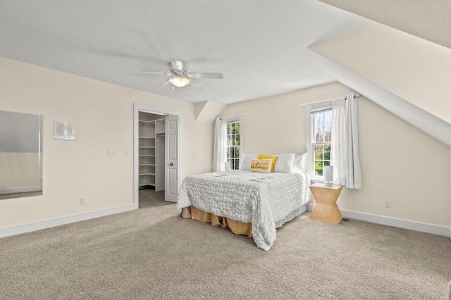 bedroom featuring a spacious closet, carpet floors, a closet, baseboards, and ceiling fan