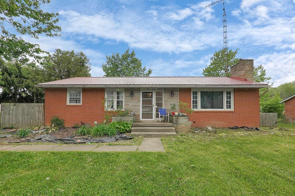 700 N Henry St, Crestline, OH 44827 - view of front of home featuring brick siding, metal roof, and a chimney