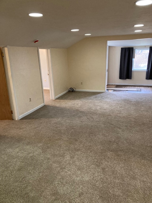 carpeted spare room featuring lofted ceiling