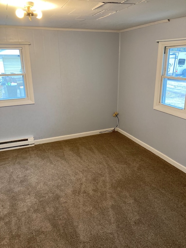 spare room with crown molding, carpet floors, and a baseboard heating unit