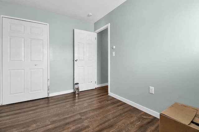 unfurnished bedroom featuring a closet and dark hardwood / wood-style floors