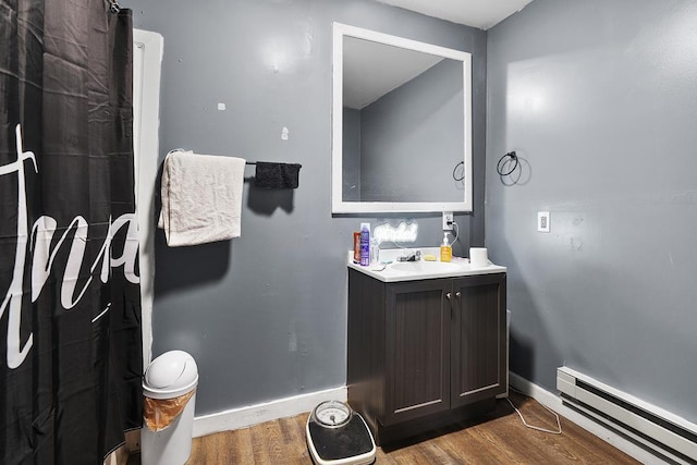 full bath with a baseboard radiator, vanity, baseboards, and wood finished floors