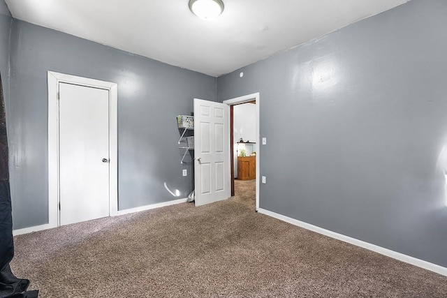 unfurnished bedroom featuring carpet and baseboards