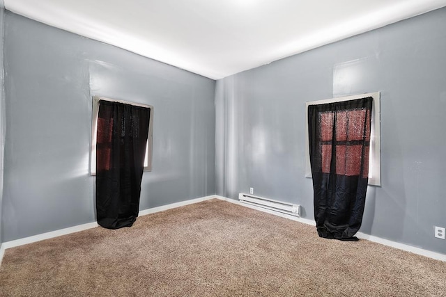 unfurnished room featuring baseboard heating, carpet, and baseboards
