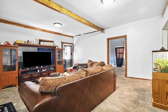 living room with baseboards, beam ceiling, and light colored carpet