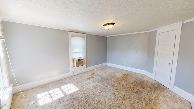 carpeted empty room with a textured ceiling, cooling unit, and ornamental molding