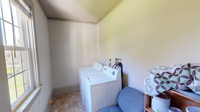 washroom with washing machine and clothes dryer and a healthy amount of sunlight