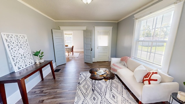 living room with dark hardwood / wood-style flooring and crown molding