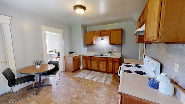 kitchen with white range oven, decorative backsplash, and sink