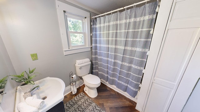 bathroom with walk in shower, a textured ceiling, and toilet