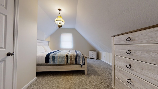 carpeted bedroom with baseboards and vaulted ceiling