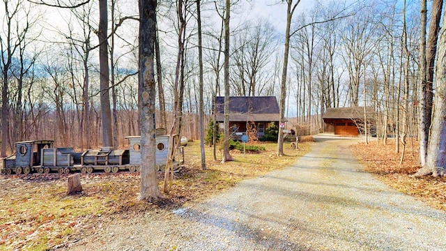 view of front of house featuring aphalt driveway and an outdoor structure