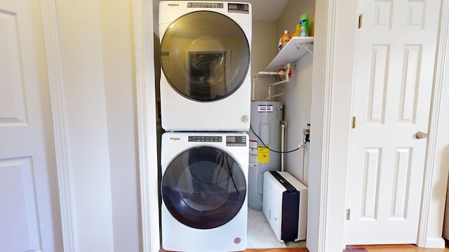 laundry area featuring laundry area, water heater, and stacked washer and clothes dryer