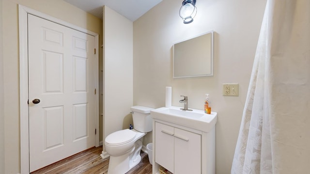 bathroom featuring toilet, wood finished floors, and vanity