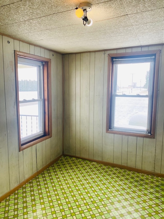 unfurnished room featuring wood walls