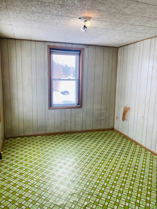 unfurnished room with wood walls