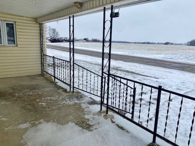 snow covered patio featuring a rural view