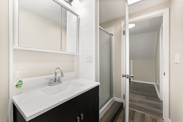 full bathroom with wood finished floors, vanity, a stall shower, and baseboards